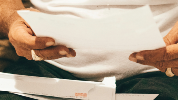 Elderly person holding paper
