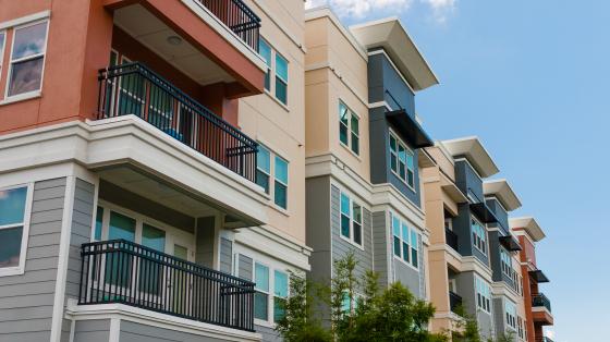 Modern luxury urban apartment building exterior with blue sky.