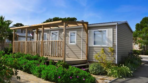 a nice mobile home with a wooden veranda in a campsite