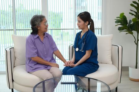 A female doctor is checking the temperature of an elderly patient.